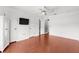 Bright bedroom with wood floors, white walls, closet, ceiling fan and a television on the wall at 2746 Heathgate Way, Land O Lakes, FL 34638