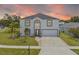 Charming two-story home with a well-manicured lawn and inviting curb appeal during a lovely sunset at 2746 Heathgate Way, Land O Lakes, FL 34638