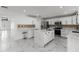 Open kitchen with white cabinetry, stainless appliances, a large center island with marble countertops, and marble floors at 2746 Heathgate Way, Land O Lakes, FL 34638