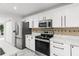 Kitchen with stainless appliances, a neutral backsplash, and white cabinetry at 2746 Heathgate Way, Land O Lakes, FL 34638