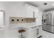 Kitchen with breakfast bar, granite countertops, stainless appliances, and white cabinets at 2746 Heathgate Way, Land O Lakes, FL 34638