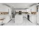 Open kitchen features white cabinetry, stainless appliances, large center island with marble countertop, and marble floors at 2746 Heathgate Way, Land O Lakes, FL 34638