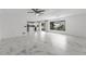 Spacious living room features marble floors, modern light fixture, and kitchen access at 2746 Heathgate Way, Land O Lakes, FL 34638