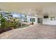 The covered patio features pavers, string lights, ceiling fan, rock garden, and a glimpse of the outdoors at 2746 Heathgate Way, Land O Lakes, FL 34638
