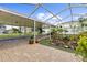 This covered patio features string lights, a ceiling fan, tile pavers, a rock garden, and a screened enclosure at 2746 Heathgate Way, Land O Lakes, FL 34638