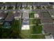 Aerial view of suburban street featuring landscaped lawns and fenced backyards with swimming pools at 3052 Living Coral Dr, Odessa, FL 33556