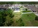 Aerial view highlighting the backyard pool, lush lawn, and fencing within a quiet residential neighborhood at 3052 Living Coral Dr, Odessa, FL 33556