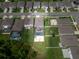 Aerial view showcases neighborhood homes with fenced backyards and a sparkling pool area, perfect for outdoor living at 3052 Living Coral Dr, Odessa, FL 33556