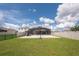Expansive backyard featuring a screened-in pool, concrete patio, and lush green lawn, ideal for relaxation and entertainment at 3052 Living Coral Dr, Odessa, FL 33556
