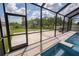 Screened-in backyard area includes access to the pool, a spa, basketball hoop, and ample green space at 3052 Living Coral Dr, Odessa, FL 33556