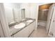 Bathroom with double vanity, granite countertop, and tile flooring and shower at 3052 Living Coral Dr, Odessa, FL 33556
