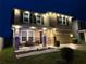 Beautiful home at dusk featuring manicured landscaping, accent lighting, and a welcoming front porch at 3052 Living Coral Dr, Odessa, FL 33556