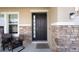 Covered front porch with stone columns and cozy seating area at 3052 Living Coral Dr, Odessa, FL 33556