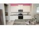 Modern kitchen with stainless steel appliances, granite countertops, and white cabinetry at 3052 Living Coral Dr, Odessa, FL 33556