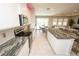 Modern kitchen features stainless appliances, granite counters, tile backsplash, and island seating at 3052 Living Coral Dr, Odessa, FL 33556