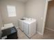 Laundry room featuring modern appliances, utility sink, and tile flooring at 3052 Living Coral Dr, Odessa, FL 33556