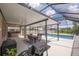 Screened-in patio features an outdoor kitchen, dining area, ceiling fans and overlooks a sparkling blue pool at 3052 Living Coral Dr, Odessa, FL 33556