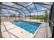 Beautiful, screened-in pool and spa offer backyard enjoyment and relaxation, completed with travertine decking at 3052 Living Coral Dr, Odessa, FL 33556