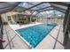Sparkling screened-in pool and spa offer relaxation and fun with a travertine deck and spacious backyard at 3052 Living Coral Dr, Odessa, FL 33556