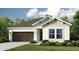 Inviting single-Gathering home featuring a two-car garage, manicured lawn, and neutral color scheme at 33618 Castaway Loop, Wesley Chapel, FL 33543