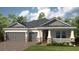 Charming single-story home with a two-car garage and beautifully landscaped front yard at 35154 Emberview Dr, Zephyrhills, FL 33541