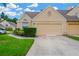 Beige home exterior featuring an attached garage, well-kept lawn, and blue sky backdrop at 3602 Pine Knot Dr # 0, Valrico, FL 33596