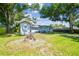 Large backyard with a fire pit and seating, surrounded by mature trees and landscaping at 3809 N 14Th St, Tampa, FL 33603