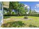 Expansive backyard with well-maintained lawn, mature trees, and a fire pit area at 3809 N 14Th St, Tampa, FL 33603