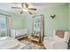 Bedroom with mint green walls, white crib and furniture, and ceiling fan at 3809 N 14Th St, Tampa, FL 33603