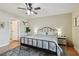 Cozy bedroom with a metal frame bed, ceiling fan, hardwood floors, and neutral decor for relaxation at 3809 N 14Th St, Tampa, FL 33603