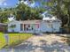 Quaint home featuring a lush front yard and a red door, accented by a lovely, covered porch at 3809 N 14Th St, Tampa, FL 33603