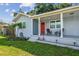 Inviting front porch with chairs, a bright red door, and manicured landscaping at 3809 N 14Th St, Tampa, FL 33603