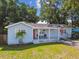 Inviting front porch with seating, a red front door, and manicured landscaping at 3809 N 14Th St, Tampa, FL 33603