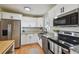 Well-lit kitchen featuring stainless steel appliances, light granite countertops, and white cabinetry at 3809 N 14Th St, Tampa, FL 33603