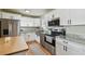 Modern kitchen features stainless steel appliances, granite counters, and white cabinetry at 3809 N 14Th St, Tampa, FL 33603