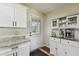 Functional Kitchen showing the door to the outside, white cabinets, granite counters, and appliances at 3809 N 14Th St, Tampa, FL 33603