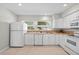 The kitchen has white appliances, plentiful cabinetry, and a sink beneath a sunlit window at 3901 17Th N Ave, St Petersburg, FL 33713