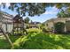 Spacious backyard with lush lawn, mature trees, and a charming playground at 4111 W Granada St, Tampa, FL 33629