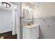Bright bathroom featuring a vanity with mirrored cabinet, tiled walls, and wood floors at 4111 W Granada St, Tampa, FL 33629
