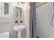 Bathroom with pedestal sink, updated fixtures, and a tiled shower, combining classic charm with modern convenience at 4111 W Granada St, Tampa, FL 33629