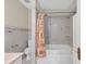 Cozy bathroom featuring a shower with an orange patterned shower curtain and tiled walls at 4111 W Granada St, Tampa, FL 33629