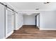 Open living space with new flooring, trim, and a decorative sliding barn door at 4111 W Granada St, Tampa, FL 33629