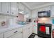 The kitchen boasts white cabinets and modern appliances for a clean and functional space at 4207 Touchton Pl # 4207, New Port Richey, FL 34652