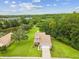 Aerial view of home showcasing its large yard, privacy trees, and proximity to a pond at 422 Cypress View Dr, Oldsmar, FL 34677