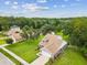 Aerial view of home with large lawn, mature trees, screened in lanai, and neighborhood pond at 422 Cypress View Dr, Oldsmar, FL 34677