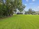 Expansive backyard featuring a lush green lawn and screened patio for outdoor enjoyment at 422 Cypress View Dr, Oldsmar, FL 34677