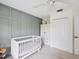 Bedroom featuring gray paneled accent wall, white crib, white closet, and ceiling fan at 422 Cypress View Dr, Oldsmar, FL 34677