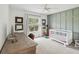 Well-lit bedroom featuring a crib, wood desk, and custom wall with views of the outdoors at 422 Cypress View Dr, Oldsmar, FL 34677