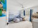 Bright bedroom with a ceiling fan, blue curtains, and a blue mountain mural for a playful touch at 422 Cypress View Dr, Oldsmar, FL 34677