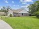 Exterior view of home featuring lush green lawn, large windows, and rear screen porch at 422 Cypress View Dr, Oldsmar, FL 34677